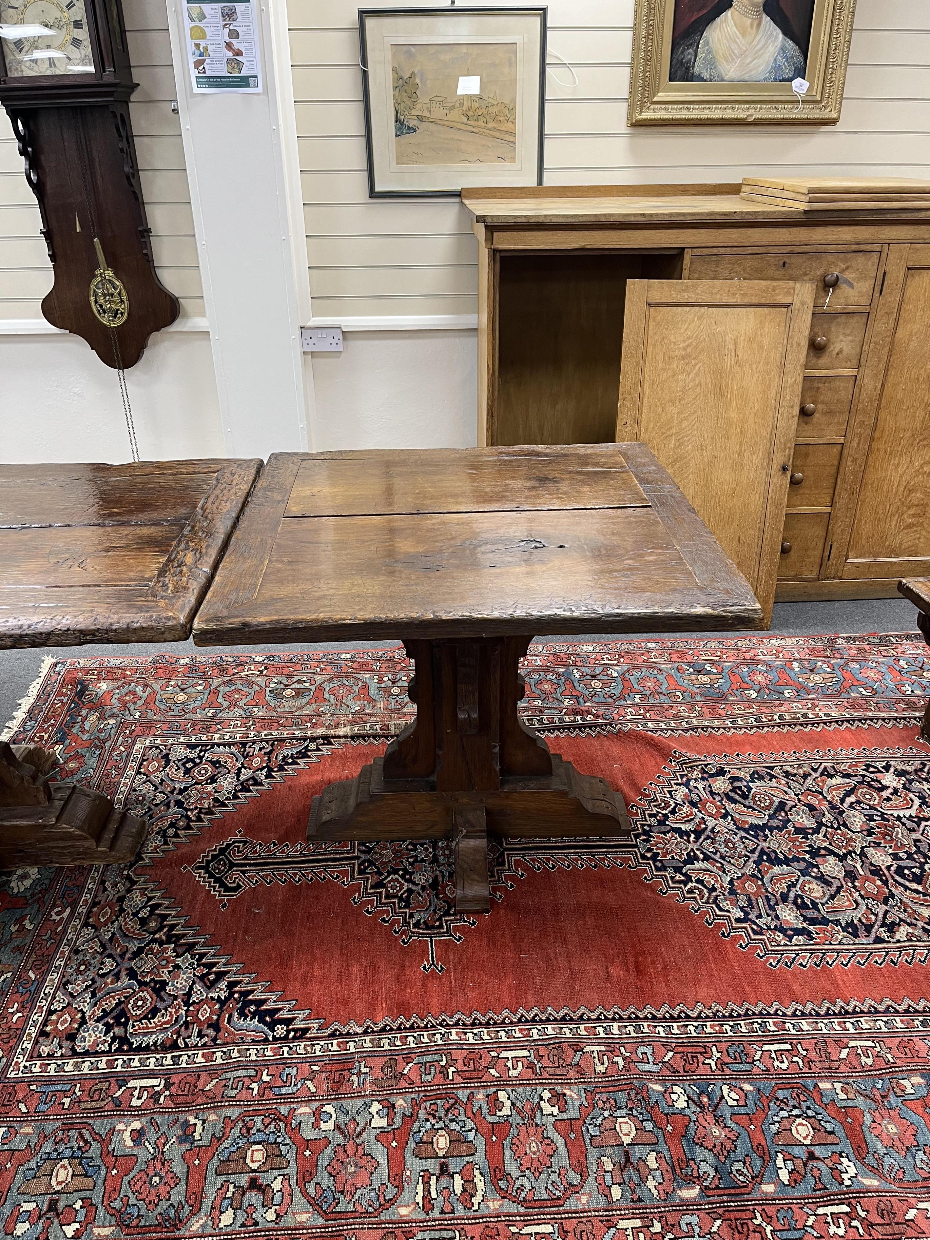 A long twin plank oak refectory dining table, in 15th century gothic style, cruciform twin pedestal base, with additional square extension table, length 365cm, 464cm with extension, depth 88cm, height 78cm. Condition - f